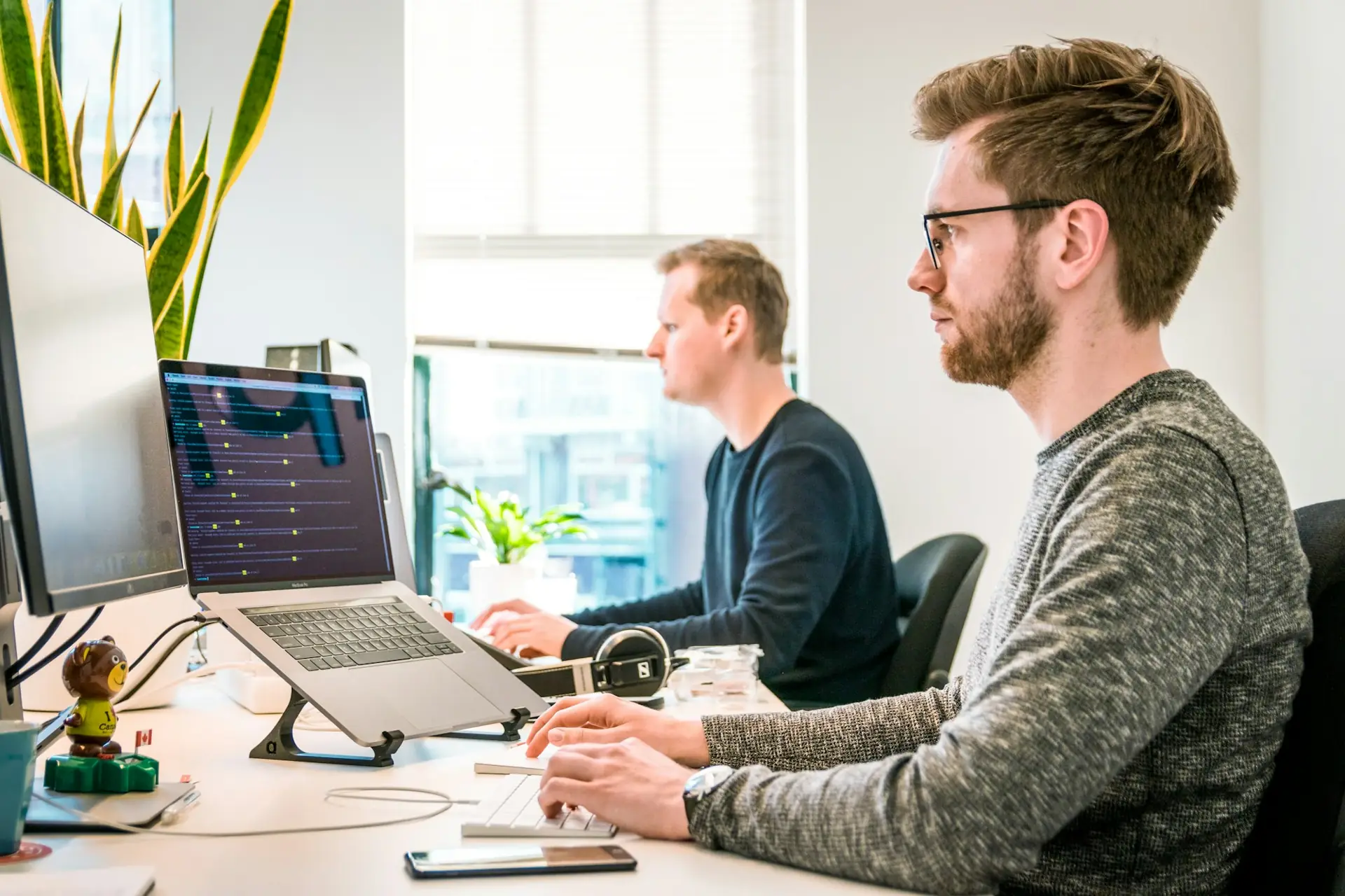 Deux techniciens travaillent sur un poste informatique dans un bureau